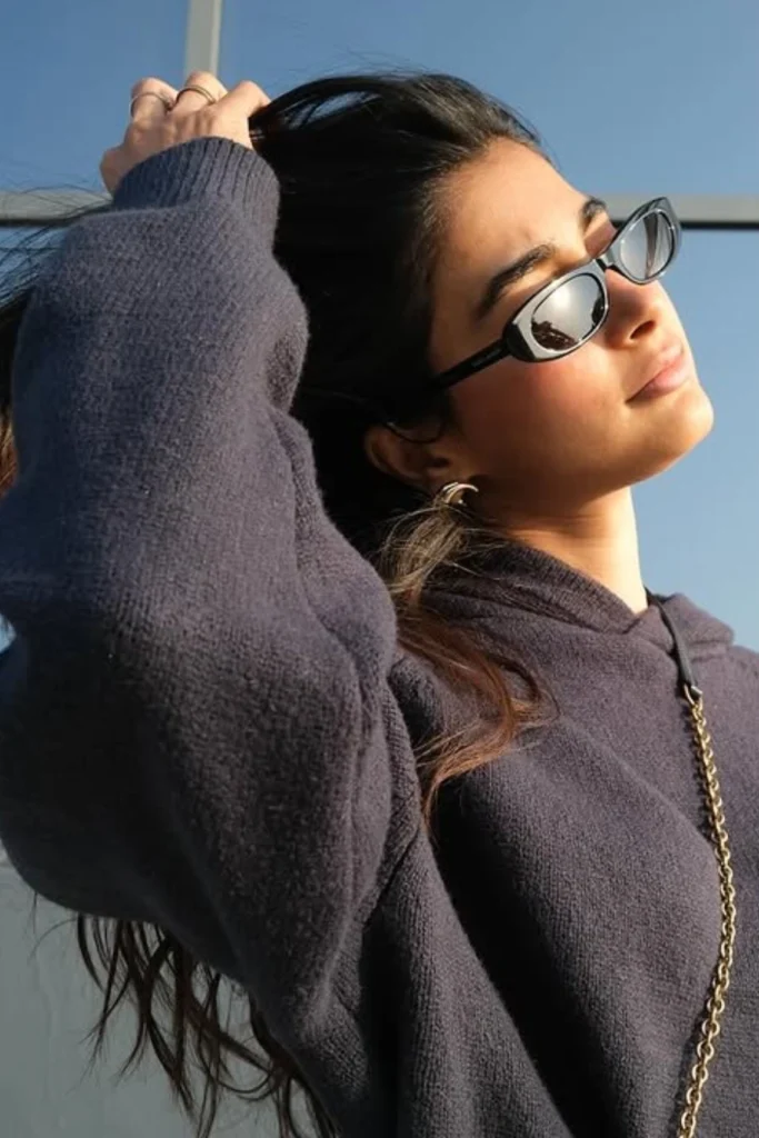 A sun-kissed photo of Pooja Hegde wearing a trendy floral dress and sunglasses while outdoors.