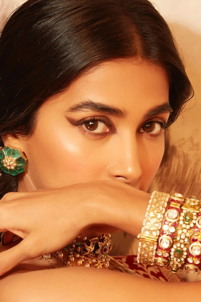 Actress Pooja Hegde posing elegantly in an embellished designer silk saree and traditional jewelry for a festive photoshoot